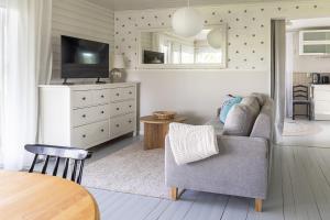 a living room with a couch and a tv at Villa Väderkulla in Porvoo