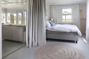 a bedroom with a bed and a couch and a window at Villa Väderkulla in Porvoo
