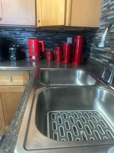 a kitchen sink with red cups on the counter at 2BR-Free parking, Near Gillette & Providence-I-95 in Pawtucket +38 photos