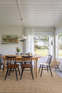 a dining room with a wooden table and chairs at Villa Väderkulla in Porvoo