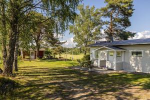 a white house with a tree and a yard at Villa Väderkulla in Porvoo