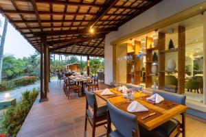 a restaurant with wooden tables and chairs on a patio at Hotel Deville Prime Salvador in Salvador