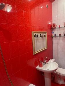 a red bathroom with a sink and a toilet at Gyumri Heritage House in Gyumri +35 photos