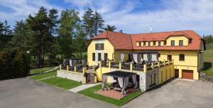 a large yellow house with a red roof at Wellness Pension AniLife in Číměř