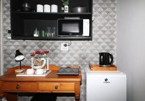 a kitchen with a desk with a microwave and a refrigerator at Nestled Peace in Klerksdorp