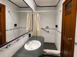 a bathroom with a sink and a mirror at Cavi Rooms 305 in Cuenca