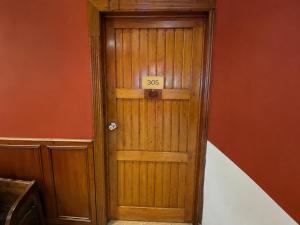 a wooden door with a sign that reads at Cavi Rooms 305 in Cuenca