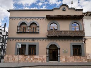 a building with a balcony on top of it at Cavi Rooms 305 in Cuenca