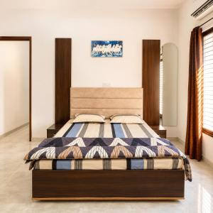 a bedroom with a bed with a wooden headboard at Amrit Farm in Rāi