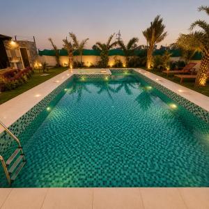 a large swimming pool in a resort at Amrit Farm in Rāi