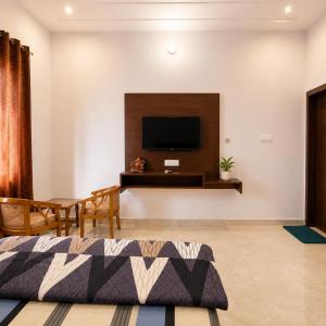 a living room with a flat screen tv on the wall at Amrit Farm in Rāi