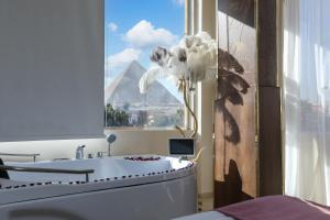 a bathroom with a white tub and a window at pyramids palace view With Rooftop Access in Cairo