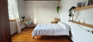 a bedroom with a white bed and a wooden floor at Casa Tía Maruja in Rianjo