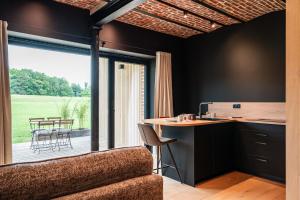 a kitchen with a large window and a table with chairs at Gîte de Thibautienne in Gedinne