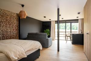 a bedroom with a bed and a brick wall at Gîte de Thibautienne in Gedinne