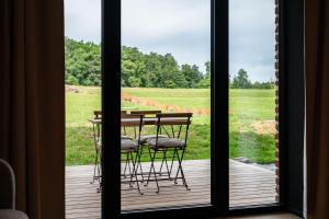a table and chairs on a porch with a view of a field at Gîte de Thibautienne in Gedinne +32 photos