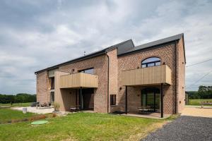 a brick house with a black roof at Gîte de Thibautienne in Gedinne