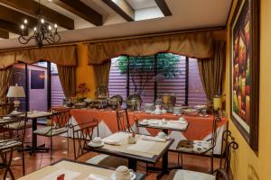 a restaurant with tables and chairs and a large window at Hotel Villa Terra in San Salvador