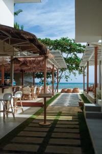 a patio with tables and chairs and the ocean at Soluna Siquijor Boutique Resort in San Juan