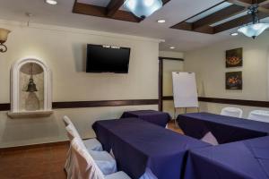 a conference room with purple tables and a flat screen tv at Hotel Villa Terra in San Salvador