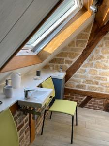 a bathroom in a loft with a sink and chairs at Le balcon in Beaumont-le-Hareng