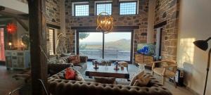a living room with leather furniture and a large window at Molivos Castleview Luxury Villa with private parking in Mythimna