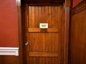 a wooden door with a sign that reads at Cavi Rooms 307 in Cuenca