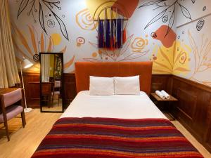 a bedroom with a bed with a colorful wall at Cavi Rooms 307 in Cuenca