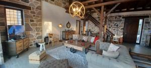 a living room with a couch and a tv at Molivos Castleview Luxury Villa with private parking in Mythimna