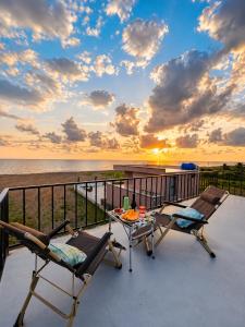 a balcony with two chairs and a table and the ocean at Trio Villas Retreat in Grigoleti