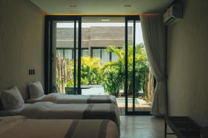 a hotel room with two beds and a large window at Koloa Concept Hotel in Barra Grande +75 photos