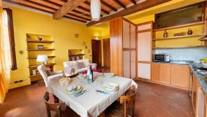 ein Esszimmer mit einem Tisch und einer Küche in der Unterkunft Simona's house in Montaione