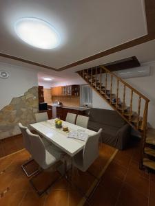 a dining room with a table and a staircase at Bozóki Apartman in Kiskunmajsa