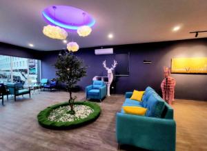 a living room with a blue couch and a tree at Hotel Wow Penang in George Town