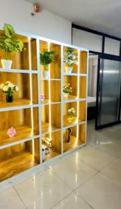 a wooden book shelf with potted plants on it at Omaxe Hazratganj Stay in Lucknow