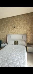 a bedroom with a white bed and two night stands at Omaxe Hazratganj Stay in Lucknow