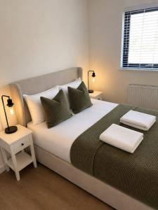 a bedroom with a large white bed with pillows at Dalhousie Residences in Carnoustie +16 photos