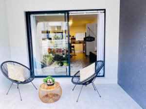 two chairs and a table with a plant on a patio at The cozy garden suites in Sandton