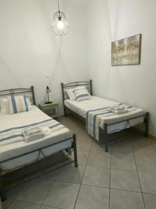 a room with two beds and a bench in it at Stella's House in Mytilinioí
