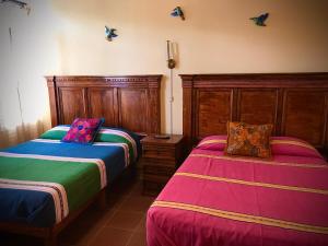 a bedroom with two beds and butterflies on the wall at Hotel Departamentos Suites in Guanajuato