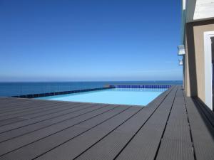 a swimming pool on a deck with the ocean in the background at Appartamento Tramonto in Castelsardo