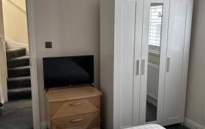a tv sitting on a dresser next to a closet at Double Room Private Bathroom Parking South Croydon in Addington