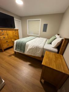 a bedroom with a bed and a television and a table at Hope Sunshine Valley Scenic Mountain View House 3BR 3Bath in Hope