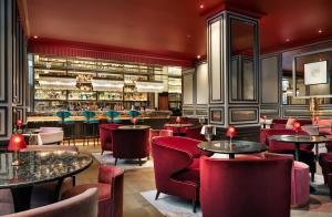 a restaurant with tables and chairs and a bar at The Biltmore Mayfair in London