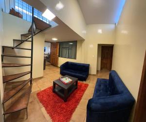 a living room with two blue couches and a red rug at Flor de Naranjo in Tabacundo