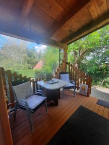 a wooden deck with a table and chairs on it at Rika Vendégház in Pécsvárad