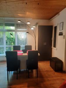 a room with a table with chairs and a lamp at Rika Vendégház in Pécsvárad