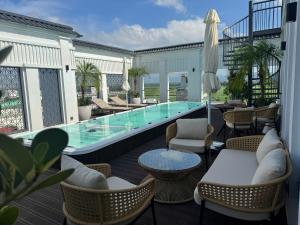 a patio with a pool and chairs and a table at Noi Bai Horizon Hotel & Spa in Noi Bai