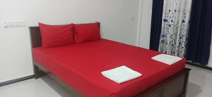 a red bed with two red pillows on it at Sivas friendly guest house in Nilaveli