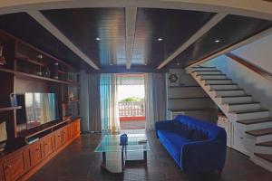 a living room with a blue couch and a staircase at Casa Barco Hotel Boutique in Isla Mujeres